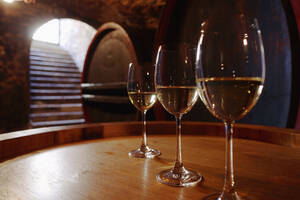 Weißwein in Gläsern auf Weinfässern - WESTF03773