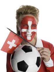 Junger Mann mit Schweizer Flagge im Gesicht, der einen Fußball und eine Flagge hält - LMF00556