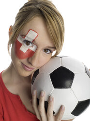 Junge Frau mit Schweizer Flagge im Gesicht und Fußball in der Hand, Porträt - LMF00549