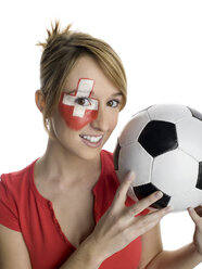 Junge Frau mit Schweizer Flagge im Gesicht und Fußball in der Hand, Porträt - LMF00548