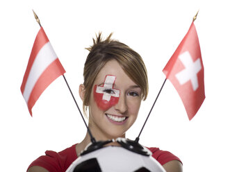 Junge Frau mit Schweizer Flagge auf dem Gesicht und hält einen Fußball mit Flagge - LMF00526