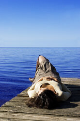 Young woman lying on jetty - LDF00400