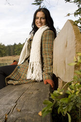 Young woman sitting on bench, side view - LDF00369