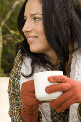 Young woman holding cup, wearing gloves - LDF00367