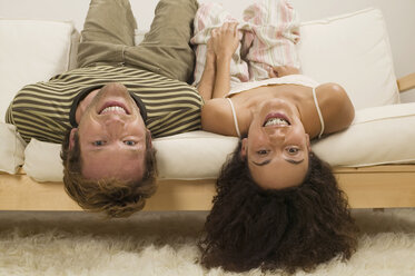 Young couple lying upside down on sofa, close-up, portrait - WESTF03709