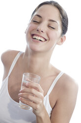 Junge Frau hält ein Glas Wasser, Augen geschlossen, lächelnd, Nahaufnahme - WESTF03210