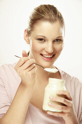 Junge Frau isst Joghurt, Porträt - LDF00432