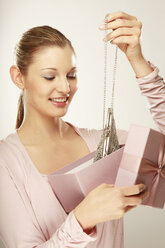 Young woman holding gift box with hand bag, smiling - LDF00423