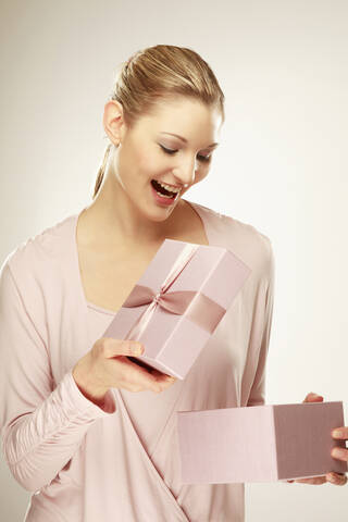 Young woman holding gift box, close-up, lizenzfreies Stockfoto