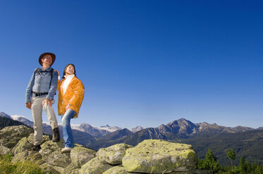 Couple in mountains, standing on rocks - HHF01104