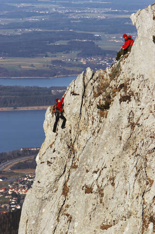 Deutschland, Bayern, zwei Personen klettern an einer Felswand, lizenzfreies Stockfoto