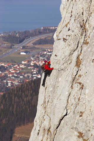 Deutschland, Bayern, Mann klettert an Felswand, Seitenansicht, lizenzfreies Stockfoto