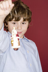 Boy holding St.Claus-shaped Christmas tree decoration - WESTF04107