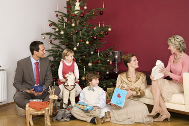 Familie sitzt unter dem Weihnachtsbaum - WESTF04053