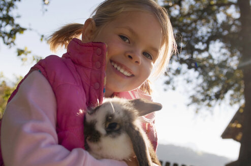 Girl (4-5) holding rabbit, portrait - HHF01221
