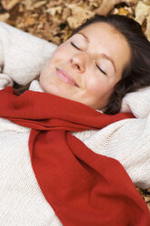 Woman lying on autumn leaves, close-up - HHF01166