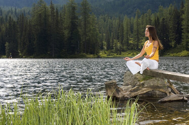 Frau übt Yoga am See, Seitenansicht - HHF01145