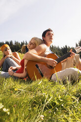 Junge Leute auf einer Wiese, Mann spielt Gitarre, tiefer Blickwinkel - WESTF04325