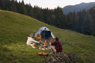 Drei junge Leute sitzen am Lagerfeuer - WESTF04314