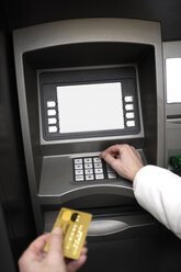 Person holding credit card, using ATM machine - 06090CS-U