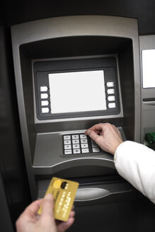 Person mit Kreditkarte, die einen Geldautomaten benutzt - 06090CS-U