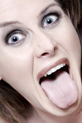 Junge Frau mit herausgestreckter Zunge, Porträt - MAEF00139