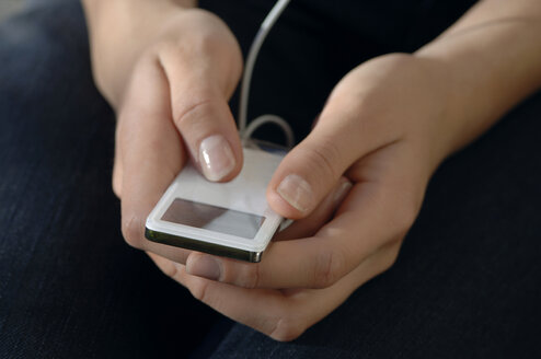 Woman using mp3-player, close-up - CRF01125