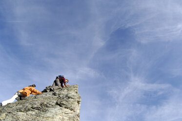 Junges Paar beim Klettern auf einem Berggipfel, tiefer Blickwinkel - WESTF04259