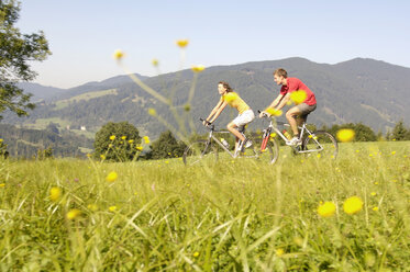 Couple riding bicycle, side view - WESTF04208