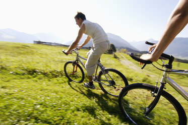 Junges Paar fährt Mountainbike, Seitenansicht, (unscharfe Bewegung) - WESTF04183