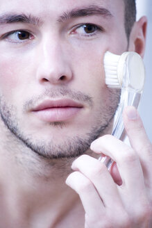 Mann massiert Gesicht mit Bürste, Nahaufnahme - MAEF00181