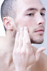 Man applying face cream, close-up - MAEF00174