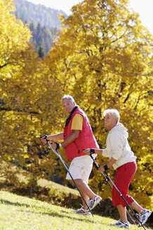 Älteres Paar beim Nordic Walking, lächelnd, Seitenansicht - WESTF04304