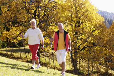 Germany, Bavaria, senior couple Nordic walking, smiling - WESTF04298