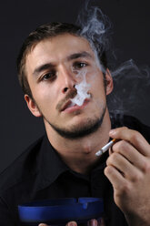 Man lighting a cigarette, portrait - CRF01160