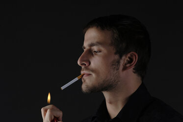 Man lighting a cigarette, portrait - CRF01158