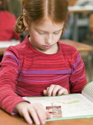 Mädchen (4-7) beim Lesen eines Schulheftes, Nahaufnahme - WESTF04574