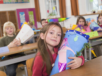 Kinder (4-7) im Klassenzimmer, die Schultüten halten - WESTF04571