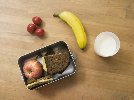 Lunchpaket auf dem Tisch, mit Sandwich, Obst und einem Glas Milch, Blick von oben - WESTF04552