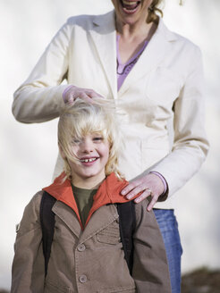 Boy (4-7) standing in front of mother, smiling, close-up - WESTF04528