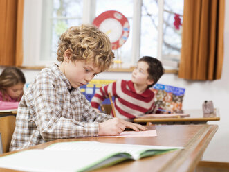 Kinder (4-7) schreiben Klausur im Klassenzimmer, Fokus auf Junge - WESTF04515