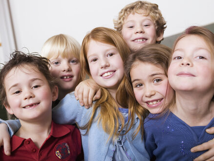 Kinder umarmen sich, schauen in die Kamera, lächeln - WESTF04440