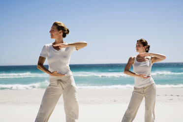 Zwei Frauen üben Yoga am Strand - WESTF04978