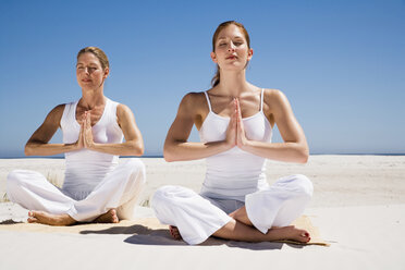 Zwei Frauen üben Yoga am Strand - WESTF04968