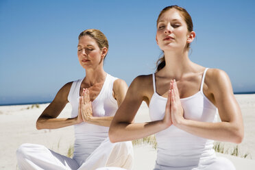 Zwei Frauen üben Yoga am Strand - WESTF04967