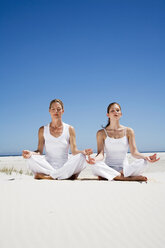 Zwei Frauen üben Yoga am Strand - WESTF04963