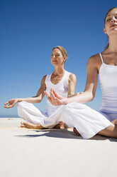 Zwei Frauen üben Yoga am Strand - WESTF04961