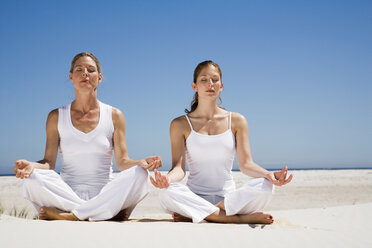 Zwei Frauen üben Yoga am Strand - WESTF04957
