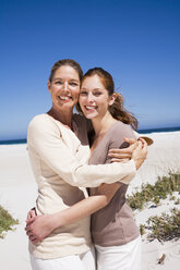Mutter und Tochter umarmen sich am Strand - WESTF04856