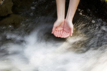 Person schröpft Wasser aus einem Bach, Nahaufnahme - WWF00287